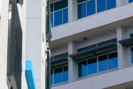 Close-up view of modern architectural design featuring a glass facade and blue accents, showcasing clean lines and minimalistic details in an urban setting.の写真素材