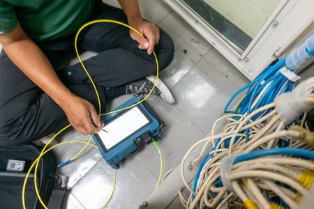 A technician conducts cable testing in a utility room, ensuring optimal connectivity and performance...