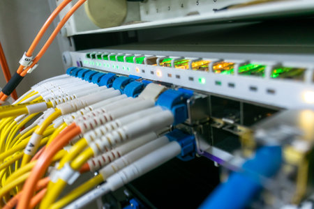 Close up of network equipment in a data center, showcasing fiber optic cables and LED indicators, illustrating modern communication technology and infrastructure.の写真素材