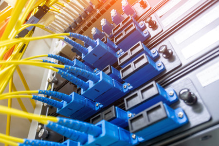 Detailed view of fiber optic cables connected to network equipment, illustrating modern data transmission technology in a structured environment.の写真素材