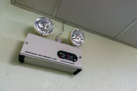 A mounted emergency light fixture with dual lamps and control panel, designed to provide illumination during power outages and emergencies.の写真素材