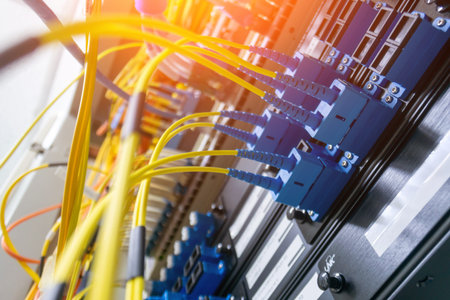 Close-up view of fiber optic cables in a data center rack, showcasing the intricate connections and...