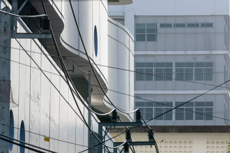 An urban scene showcasing modern architecture with contrasting geometric lines and power lines. The...