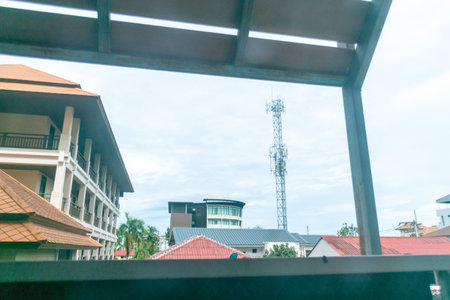 This image showcases a city view featuring multiple buildings and a communication tower. It highlights urban architecture against a cloudy sky, portraying city life.の写真素材