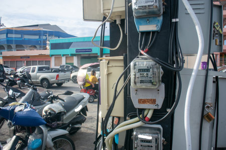 A close-up view of utility meters installed in an urban parking area, showcasing the infrastructure necessary for electricity management alongside parked vehicles.の写真素材