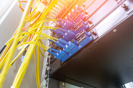Detailed close-up of a fiber optic network connection system showcasing cables and connectors,...