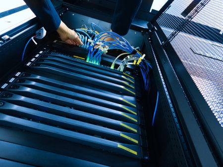 An expert technician manages server cables inside a data center, focusing on optimal connectivity...