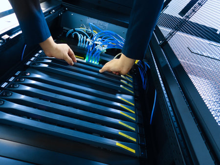 A technician performing server maintenance, organizing network cables in a server rack. This image...