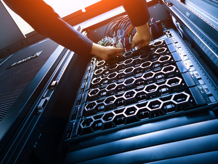 A technician works on the internal setup of a server rack, focusing on organizing cables and...