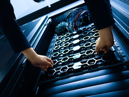 A technician performs maintenance on a server rack in a data center. Cables and hardware components are meticulously organized for optimal performance and security.の写真素材