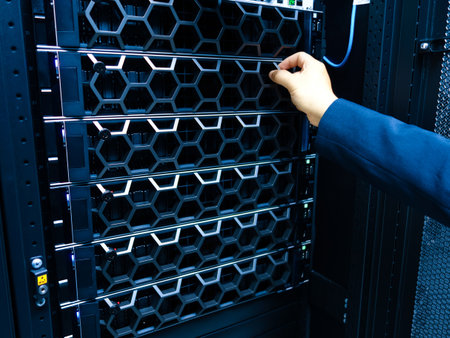 A technician performs maintenance on a server rack in a modern data center, focusing on optimal hardware setup and ensuring high performance and reliability.の写真素材