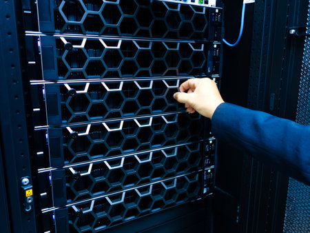 A professional hand adjusts a server in a high-tech data center, showcasing advanced hardware organization and maintenance. Ideal for technology-related themes.の写真素材