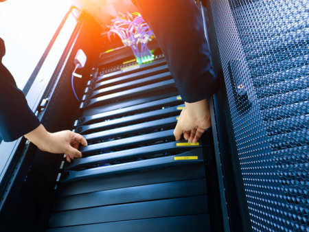 A technician inspects a server rack, ensuring proper connections and optimal performance for efficient data management and technology operations.の写真素材