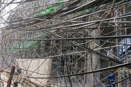 Chaotic view of a construction site displaying scaffolding and tangled cables, highlighting the intricate details of urban development and teamwork in progress.の写真素材