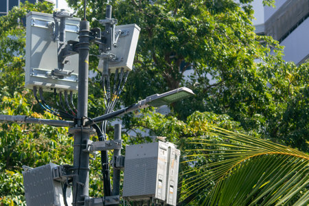 Close-up view of communication equipment mounted on an urban pole, showcasing technology integration with natural surroundings, signifying modern connectivity advancements.の写真素材
