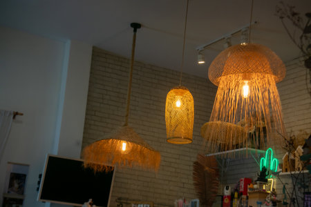 This image showcases a stunning arrangement of modern woven lighting fixtures that create a warm and inviting ambiance in a contemporary interior space.の写真素材