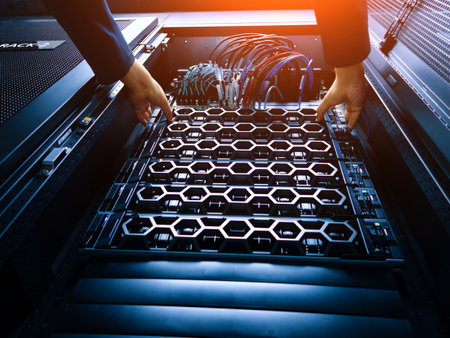 A technician carefully installs server components into a data center rack, showcasing modern technology and hardware management in a professional setting.の写真素材