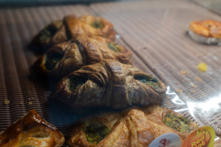 A captivating display of freshly baked spinach puff pastries, showcasing their flaky crust and inviting texture, perfect for food lovers and culinary enthusiasts.の写真素材