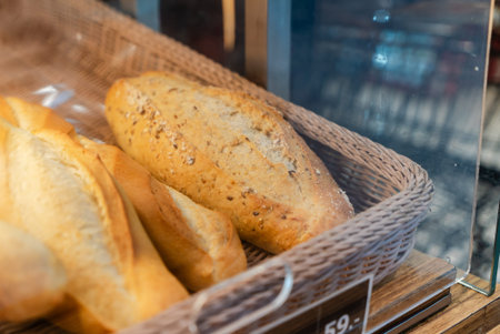 A display of freshly baked bread featuring a golden crust, showcasing a variety of loaves in a...