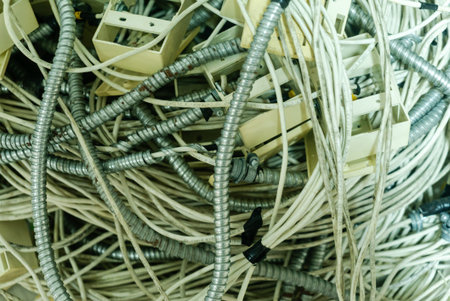 A chaotic arrangement of tangled wires and cables, showcasing the complexity of electronic...