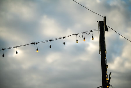Charming string lights hang above a cloudy sky, creating a warm and inviting atmosphere. Perfect for...