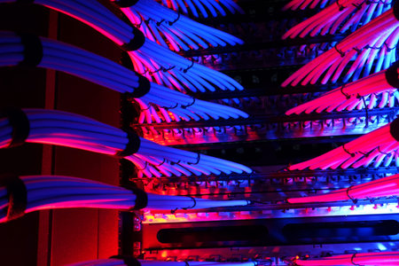 A vibrant view of network cables glowing in blue and purple hues, showcasing the intricate design of...