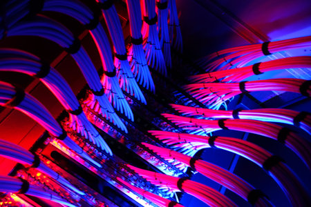 A striking view of network cables illuminated with colorful lighting, showcasing technology and...