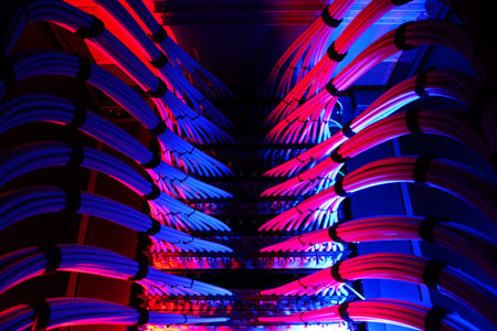 A vibrant display of network cables illuminated by red and blue lights emphasizes the technological...