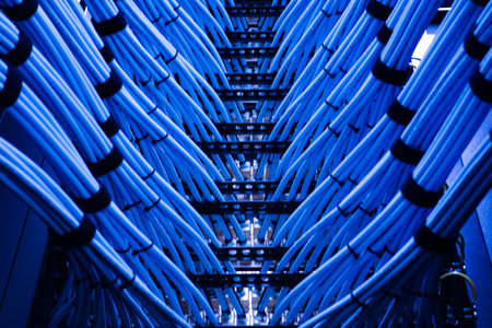A striking view of blue data cables arranged in a server rack, showcasing the intricate network of...