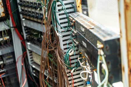 Close-up view of tangled wires and cables in an electrical control panel. This image highlights the...
