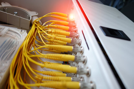 Close-up view of yellow fiber optic cables in a data communication setup. This image showcases technology infrastructure used for data transmission.の写真素材