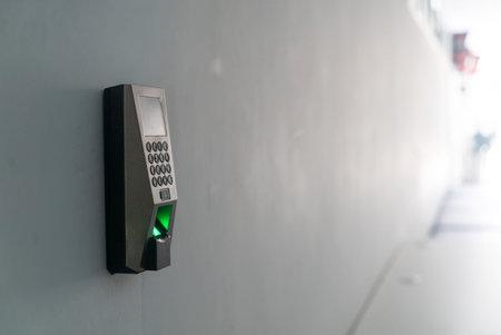 A modern biometric fingerprint scanner device mounted on a wall, showcasing advanced security...