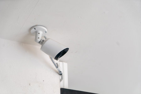 A detailed view of a ceiling mounted security camera in an indoor setting, highlighting its design...