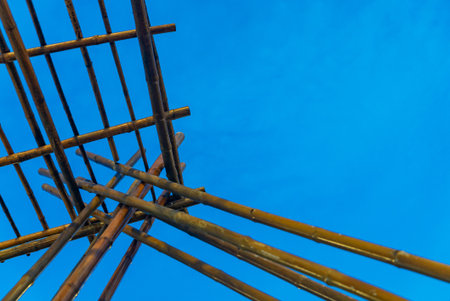 A stunning view of a bamboo structure set against a clear blue sky. The image showcases minimalist design, emphasizing angles and natural materials.の写真素材
