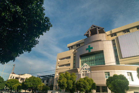 A modern pharmacy building showcases contemporary architecture under a clear blue sky. Green signage stands out against the facade, enhancing accessibility and visibility.の写真素材