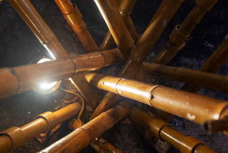 A captivating view of a bamboo structure illuminated by a soft light source, showcasing the natural beauty and intricate angles of the design. Ideal for interior decor concepts.の写真素材