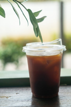 A refreshing iced coffee served in a clear cup, surrounded by a serene outdoor setting. Perfect for...