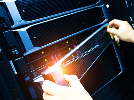 This image showcases the hands of a technician performing maintenance on servers inside a data...