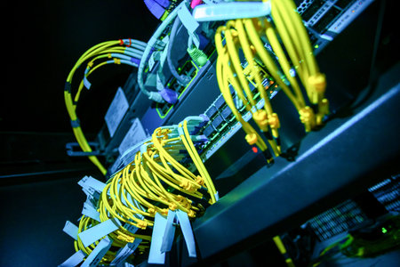 Vibrant fiber optic cables connect various network switches in a data center, illustrating modern...