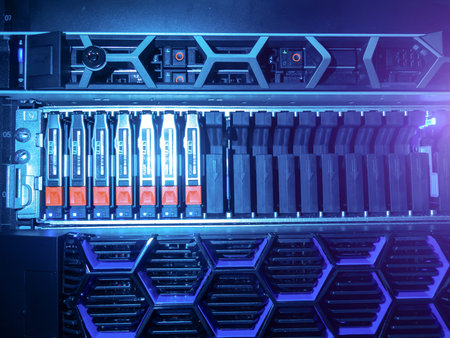 A close-up view of a server storage array featuring active drives illuminated by blue lighting. This...