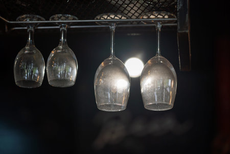 A close-up of hanging glassware in a bar, featuring elegant design and soft light reflections. Ideal...