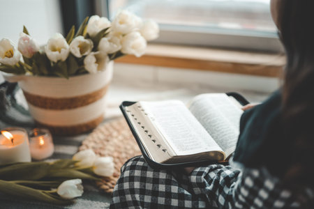Girl holding an open bible in her hands, home study concept.