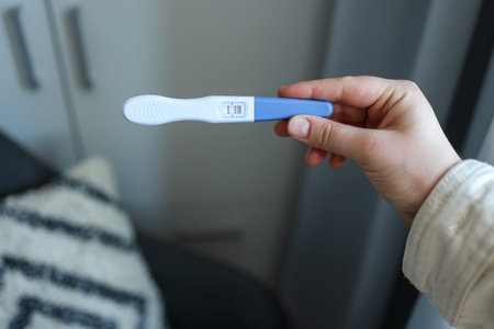 Positive pregnancy test in hand.