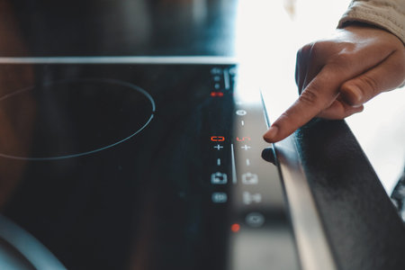 Close-up of turning on electric stove. Action. Turning on electronic plate panel. Panel with touch...