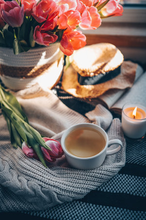 Cup of tea and bouquet of tulips on the windowsill