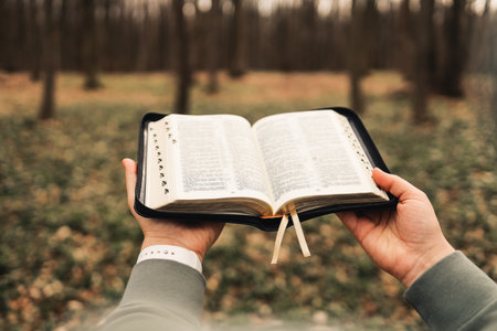 Illustration of a girl holding an open Bible against a forest backdrop.