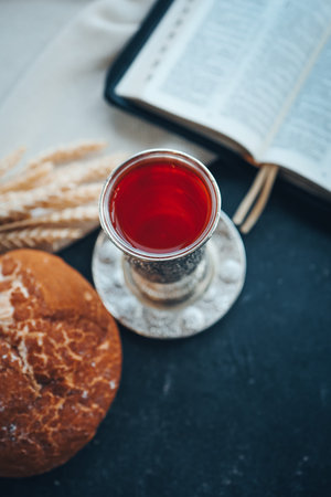 Bread, wine and ears of wheat on a dark background.