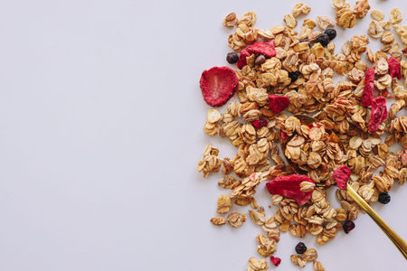 Granola on spoon isolated on white background, copy space. Healthy snack or breakfast concept -...