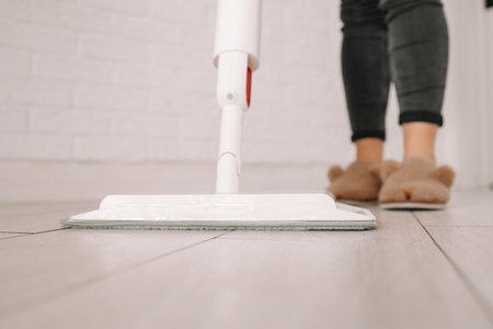 Cleaning Service Woman Mopping The Floor In Kitchen At Home