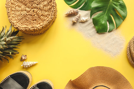 Colorful summer female fashion outfit flat lay. Straw hat, wicker shoes, pineapple over yellow...